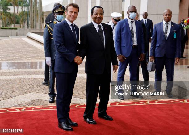 France's President Emmanuel Macron poses with Cameroon's President Paul Biya as he arrives for talks at the Presidential Palace in Yaounde, on July...