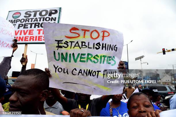 Workers hold banners as they take part in a rally called by trade unions at Ikeja, north of Lagos, on July 26, 2022. - The Nigerian Labour Congress...