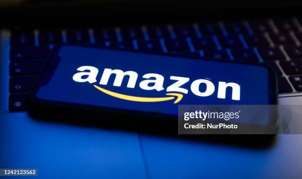 Amazon logo displayed on a phone screen and a laptop keyboard are seen in this illustration photo taken in Krakow, Poland on July 26, 2022.