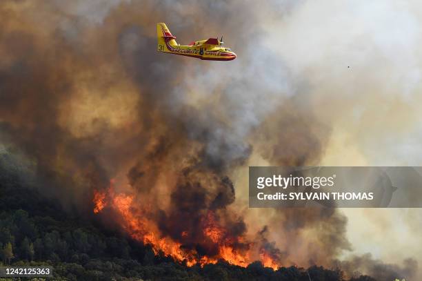 French Securite Civile Canadair CL-415 firefighting aircraft passes over burning forests near Gignac, southern France, on July 26 as the country...