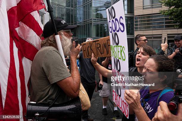 Protesters calling for the indictment of Donald Trump argue with a supporter of the former president outside the America First Agenda Summit on July...