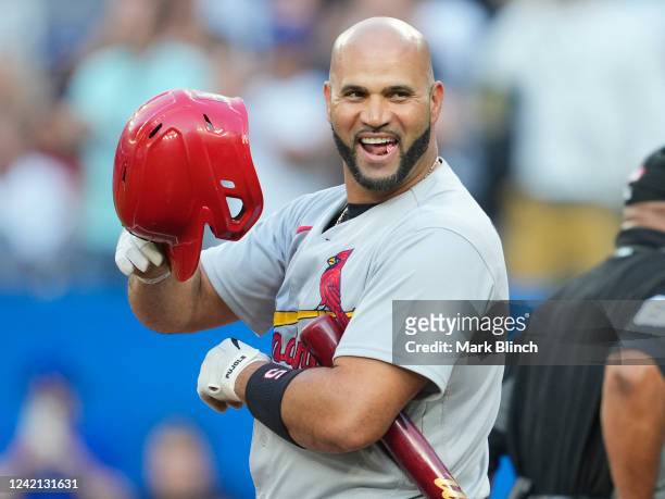 Albert Pujols of the St. Louis Cardinals tips his helmet to the crowd in a break against the Toronto Blue Jays in the first inning during their MLB...