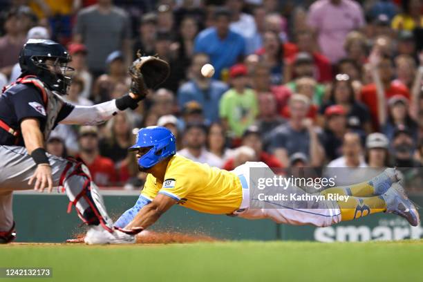 Xander Bogaerts of the Boston Red Sox dives but is tagged out at the plate by Austin Hedges of the Cleveland Guardians in the third inning at Fenway...