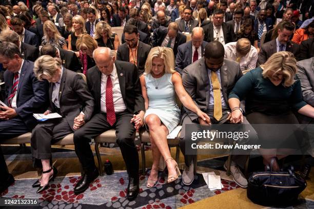 Rep. Louie Gohmert and Rep. Marjorie Taylor Greene pray with other lawmakers and audience members at the America First Agenda Summit, at the Marriott...