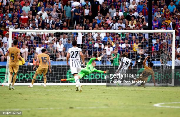 Moise Kean of Juventus scores a goal as FC Barcelona goalkeeper Marc Stegen of FC Barcelona dives during the first half of a 2022 International...