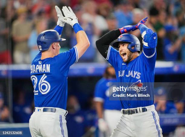 George Springer of the Toronto Blue Jays celebrates his grand slam with Matt Chapman against the St. Louis Cardinals in the sixth inning during their...