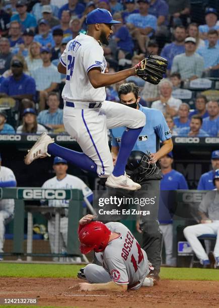 Relief pitcher Amir Garrett of the Kansas City Royals leaps over Phil Gosselin of the Los Angeles Angels as Gosselin scores on a wild pitch in the...