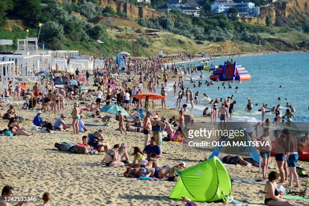 People relax on a beach of the Black Sea in Sevastopol, the largest city on the Crimean Peninsula and its most important port and naval base, on July...