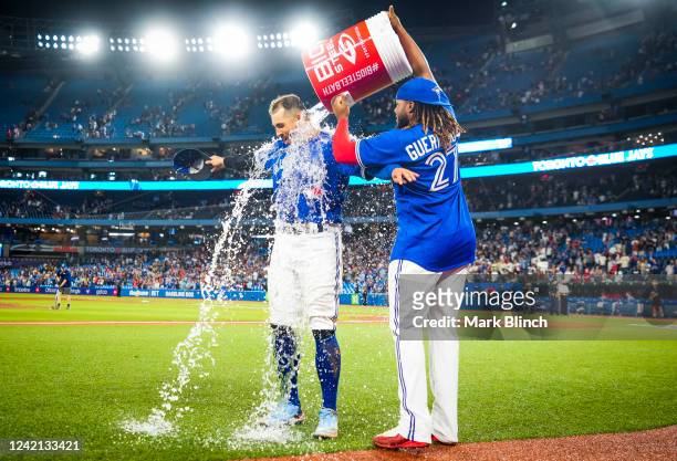 Vladimir Guerrero Jr. #27 of the Toronto Blue Jays dumps water on George Springer in the post game interview after their team defeated the St. Louis...