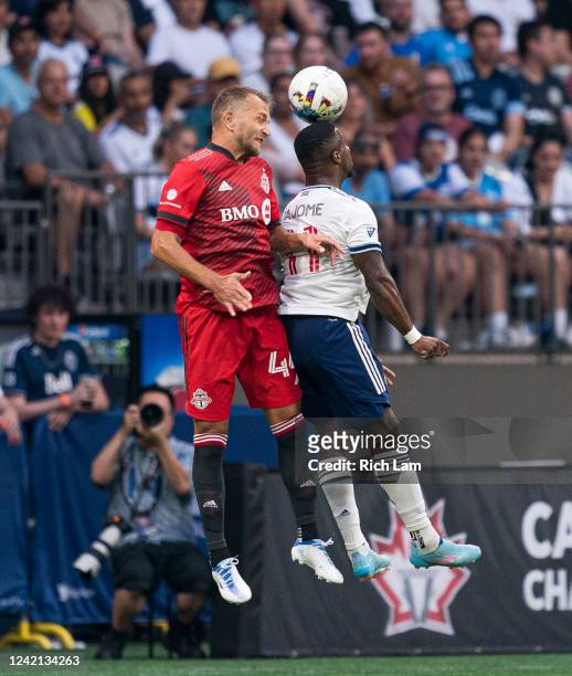Cristian Dajome of the Vancouver Whitecaps FC win a header against Domenico Criscito of the Toronto FC during the first half of the 2022 Canadian...