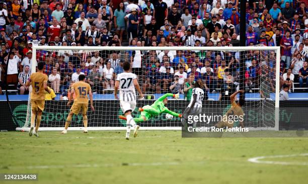 Moise Kean of Juventus scores a goal as FC Barcelona goalkeeper Marc Stegen of FC Barcelona dives during the first half of a 2022 International...