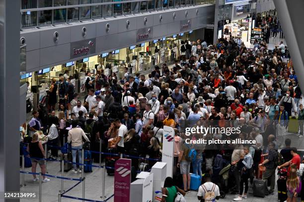 July 2022, North Rhine-Westphalia, Duesseldorf: Travelers stand in lines in front of the check-in counters in the terminal. Due to the Verdi warning...