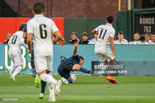 Club America's Uruguayan forward Federico Vinas takes a tumble while fighting for the ball against Real Madrid's Spanish forward Marco Asensio during...