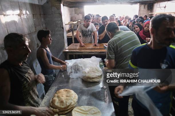 Long lines form early on July 27, 2022 outside a bakery in north Lebanon's port city of Tripoli where people sometimes have to wait for hours for a...