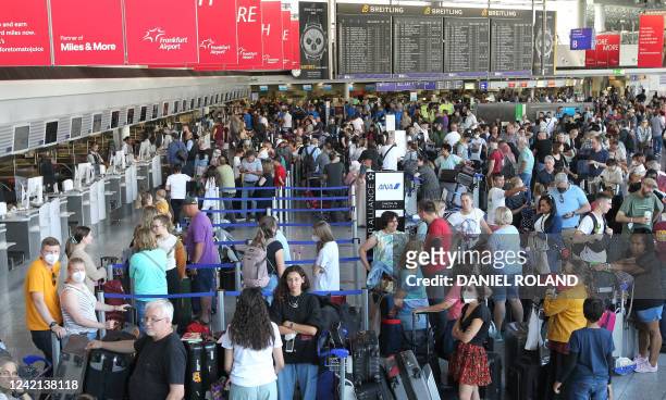 Passengers wait and queue in front of counters for departure at Frankfurt Airport in Frankfurt am Main, western Germany, on July 27 after employees...