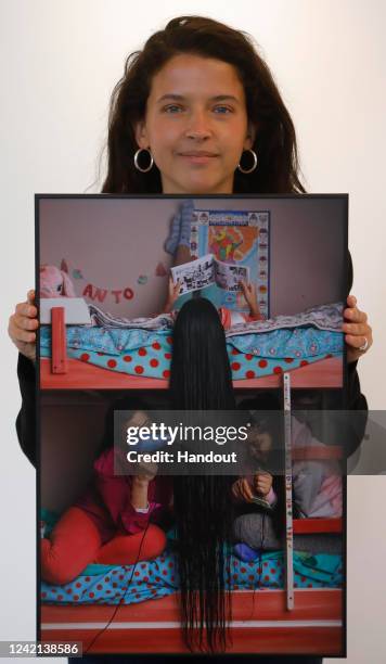 In this handout photo provided by the Scottish Government, World Press Photo Curator Marika Cukrowski Pictured with a photo by Irina Werning of...