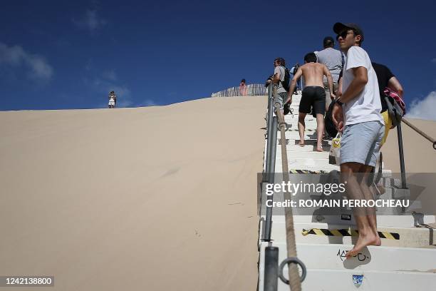 People walk the stairs on the Dune du Pilat, Europe's highest sand dune, on the day of its re-opening after a huge wildfire destroyed 7000 hectares...