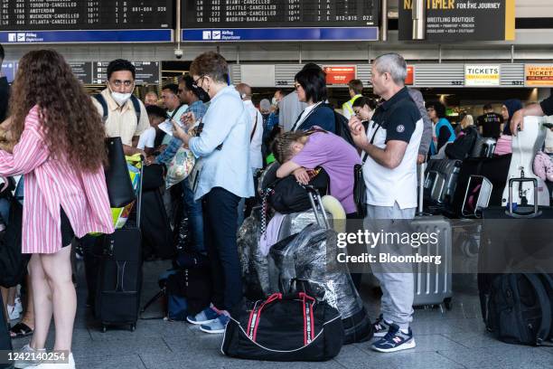 Travelers queue in front of flight information boards displaying cancelled flights in the departures hall at Terminal 1 of Frankfurt Airport in...