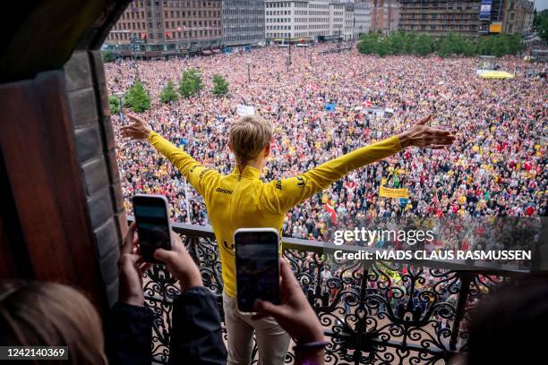 Jumbo-Visma team's Danish rider Jonas Vingegaard, winner of the 2022 Tour de France, waves from a balcony as he is welcomed by fans upon arrival at...