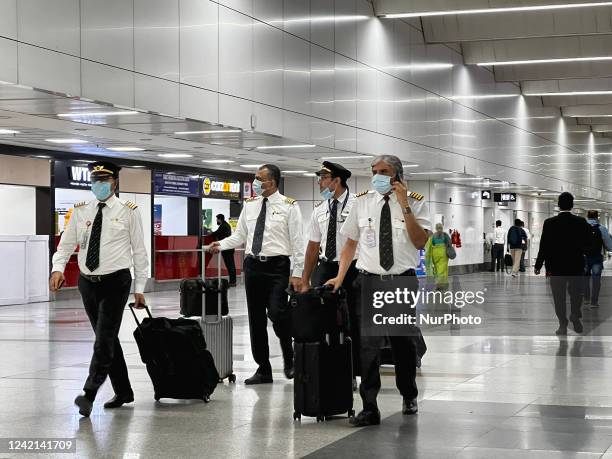 Pilots and flight crew walk through Indira Gandhi International Airport in Delhi, India, on May 31, 2022.