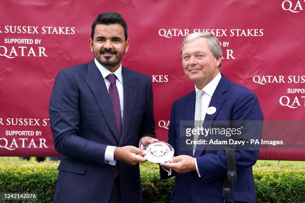 Sheikh Joaan bin Hamad Al Thani presents trainer William Haggas with a trophy after victory in the Qatar Sussex Stakes for horse Baaeed on day two of...