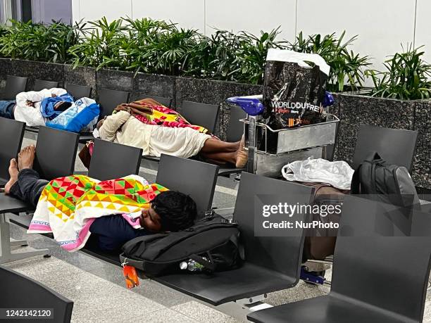 Travellers sleep in the early hours of the morning while waiting for a connecting flight at Indira Gandhi International Airport in Delhi, India, on...