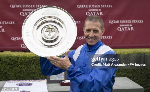 Jockey Jim Crowley holds up The Qatar Sussex stakes trophy after winning on BAAEED on day two of the Qatar Goodwood Festival 2022 at Goodwood...