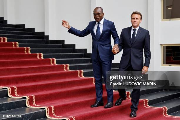 Beninese President Patrice Talon welcomes France's President Emmanuel Macron at the Marina palace in Cotonou on July 27 during Macron's official...