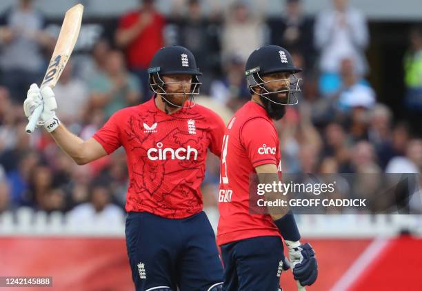 England's Jonny Bairstow celebrates after scoring a half-century as teammate Moeen Ali looks on during the first T20 international cricket match...