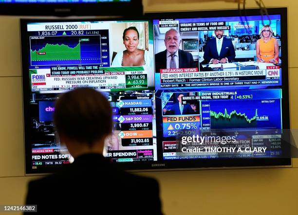 Person on the floor of the New York Stock Exchange watches TV screens on July 27, 2022. - US Federal Reserve on Wednesday again raised the benchmark...