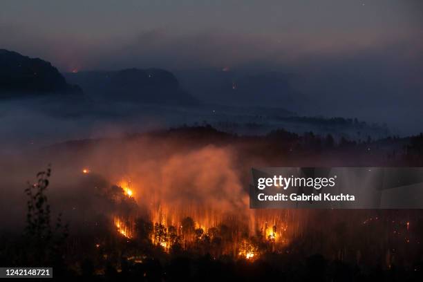 Long exposure photo shows a general view of burning areas in a forest on July 27, 2022 in Hrensko, Czech Republic. The fire broke out on Sunday and...