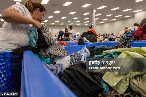 People sift through used clothes that are sold by the pound at a Goodwill Outlet Center on July 27, 2022 in Hackensack, New Jersey. Goodwill and...