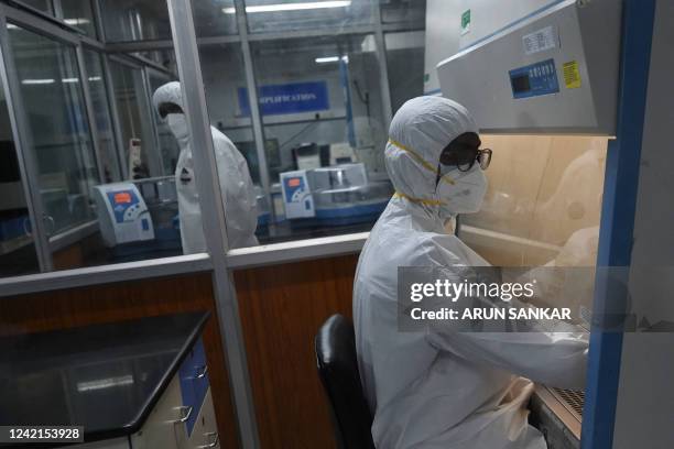 Technicians wearing personal protective equipment suits are seen inside a molecular laboratory facility set up to test for the monkeypox disease...