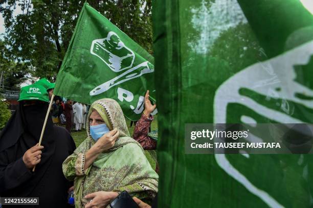 Supporters of the Peoples Democratic Party wave party flags as PDP leader Mehbooba Mufti speaks during a rally in Srinagar on July 28, 2022.
