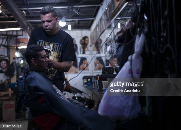 Man receives a haircut at a barber shop in Rio de Janeiro, Brazil on July 27, 2022 as the whole world observes the 28th of July World Hepatitis Day....