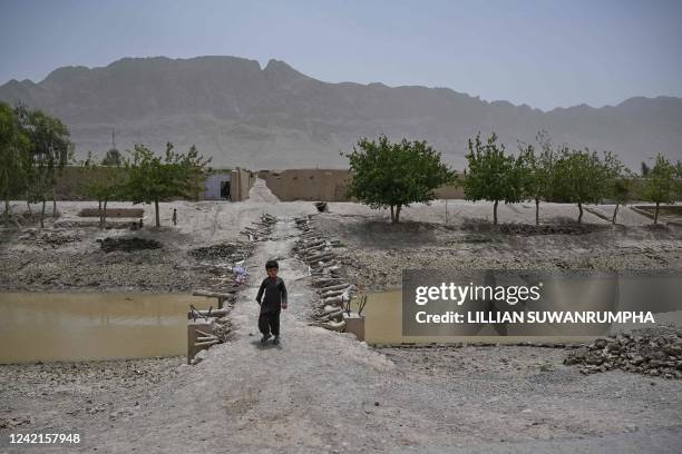 This photograph taken on July 23, 2022 shows a boy standing on the road leading to a village on the outskirts of Kandahar.