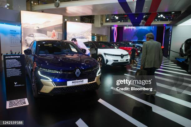 Customers look at the Renault SA Megane E-tech electric vehicle at the L'Atelier Renault flagship store on the Champs Elysees in Paris, France, on...
