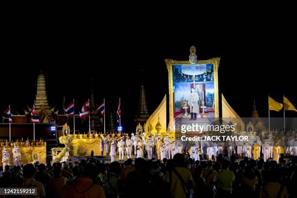 Officials gather around a portrait of Thailand's King Maha Vajiralongkorn outside the Grand Palace during celebrations to mark the King's 70th...