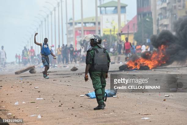 Police officer looks on as protesters block roads and hurl rocks in Conakry on July 28 after authorities prevented supporters of the opposition...