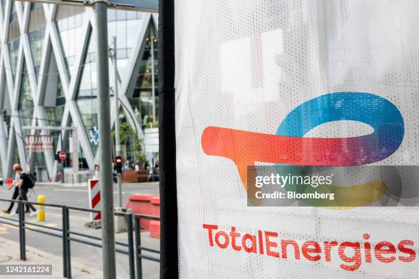 Signage for TotalEnergies SE at the company's electric vehicle charging station in the La Defense business district in Paris, France, on Thursday,...