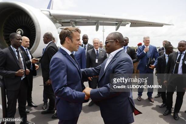 French President Emmanuel Macron greets Guinea-Bissau's President Umaro Sissoco Embalo before leaving at Bissau's airport, on July 28, 2022 after a...