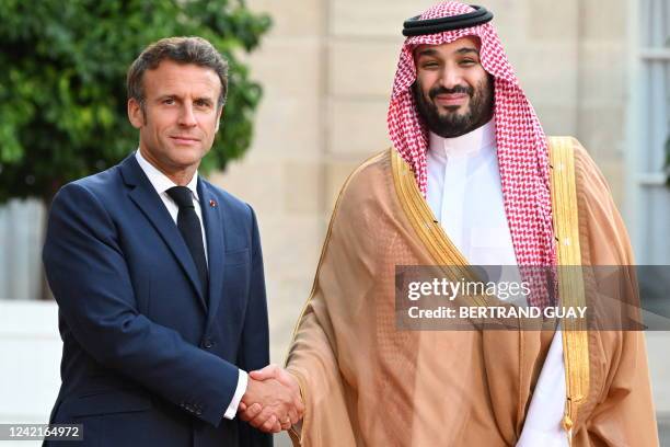 France's President Emmanuel Macron greets Saudi Crown Prince Mohammed bin Salman as he arrives at presidential Elysee Palace in Paris on July 28,...