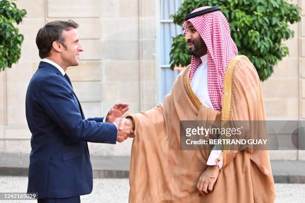 France's President Emmanuel Macron greets Saudi Crown Prince Mohammed bin Salman as he arrives at presidential Elysee Palace in Paris on July 28,...