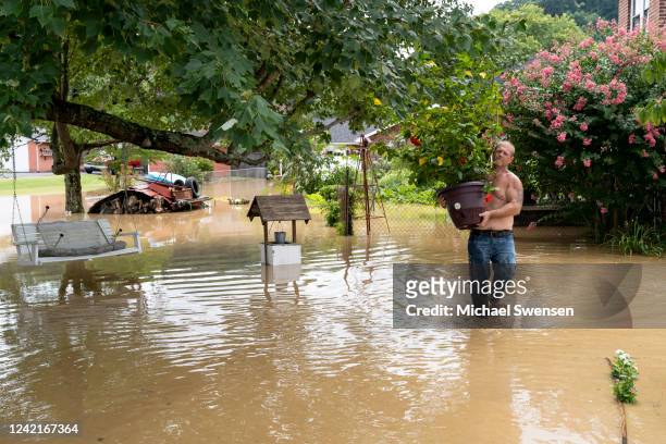 Cristopher Howard carries plants from his garden on July 28, 2022 in downtown Jackson, Kentucky, where the flooding is not expected to reach its peak...