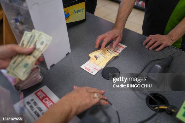 People buy their Mega Millions lottery tickets at a 7-Eleven convenience store in Chino Hills, California, July 28, 2022. The odds of claiming this...