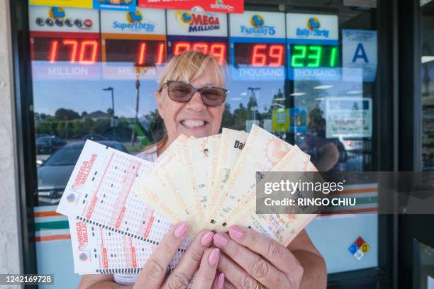 Liz Evans shows off her Mega Millions lottery tickets at a 7-Eleven convenience store in Chino Hills, California, July 28, 2022. The odds of claiming...