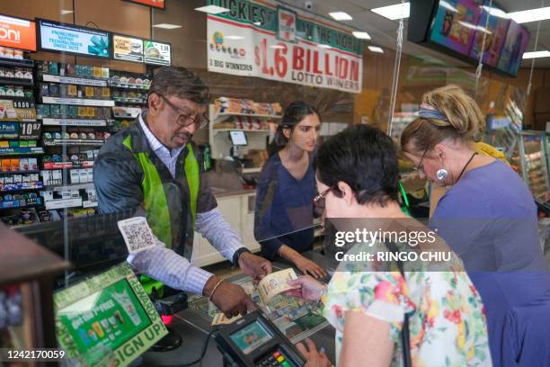 People buy their Mega Millions lottery tickets at a 7-Eleven convenience store in Chino Hills, California, July 28, 2022. The odds of claiming this...