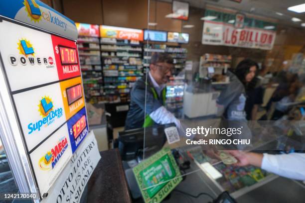 People buy their Mega Millions lottery tickets at a 7-Eleven convenience store in Chino Hills, California, July 28, 2022. The odds of claiming this...