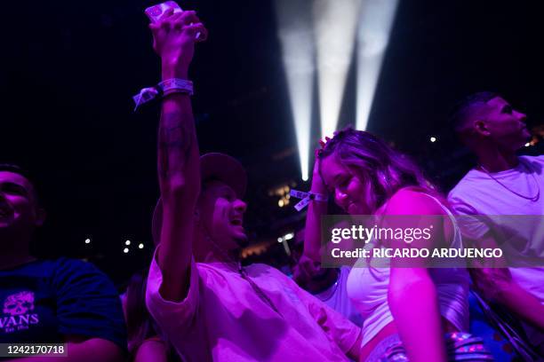 Fans dance as they watch Puerto Rican rapper Bad Bunny perform on stage as part of his three-day "Un Verano Sin Ti" concert at the Coliseo de Puerto...