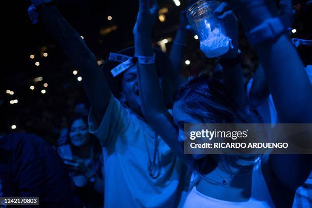 Fans dance as they watch Puerto Rican rapper Bad Bunny perform on stage as part of his three-day "Un Verano Sin Ti" concert at the Coliseo de Puerto...